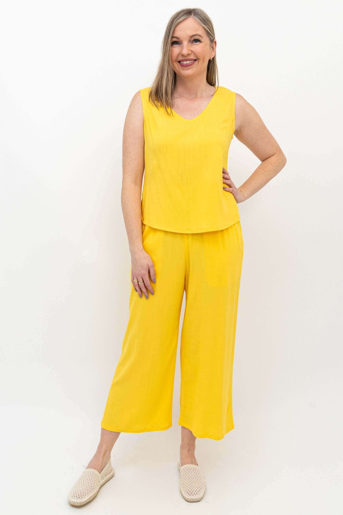 Full body view of woman in yellow bamboo-linen cropped tank and matching pants