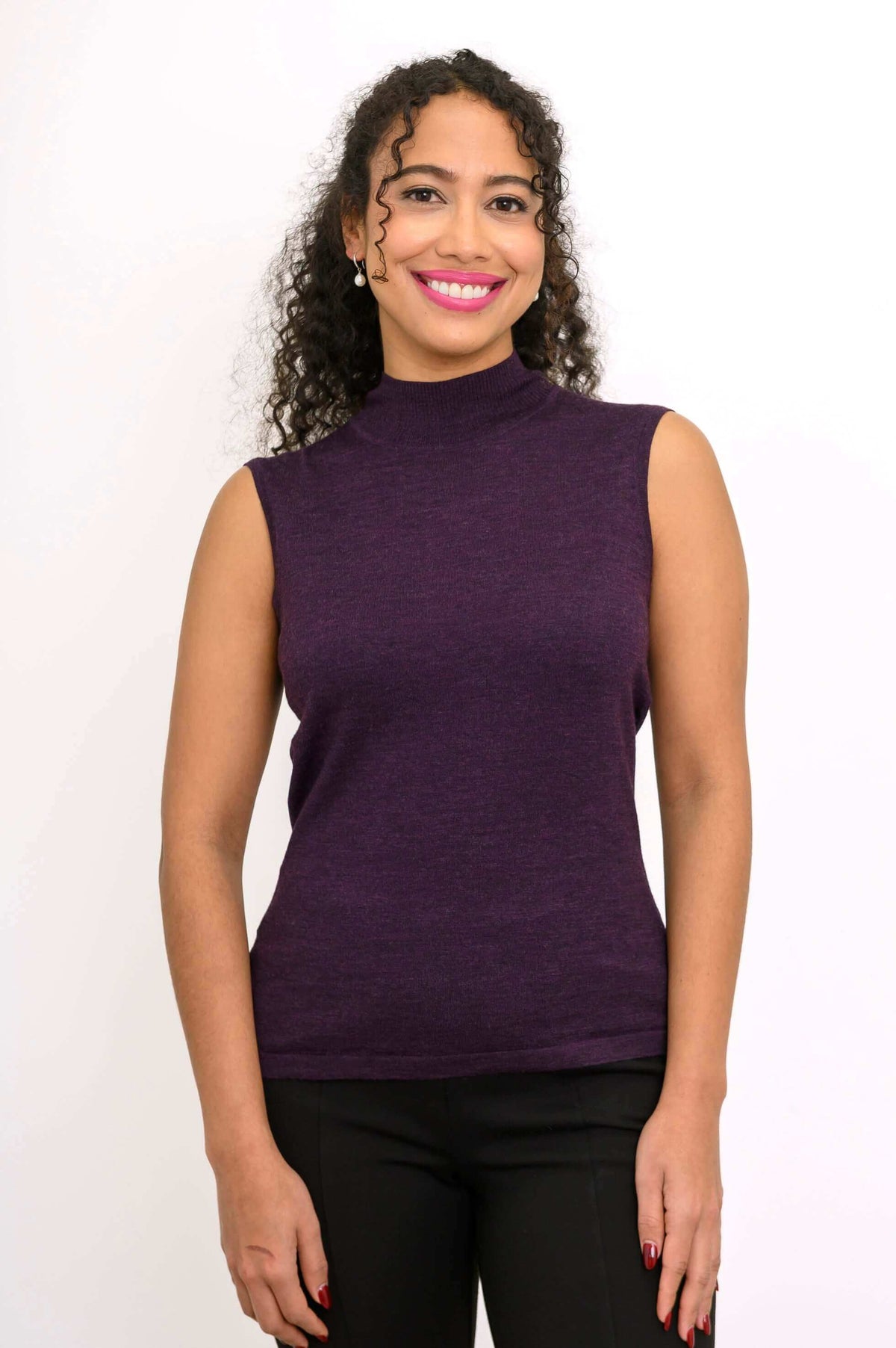Woman facing forward in sleeveless purple Merino wool mock neck sweater