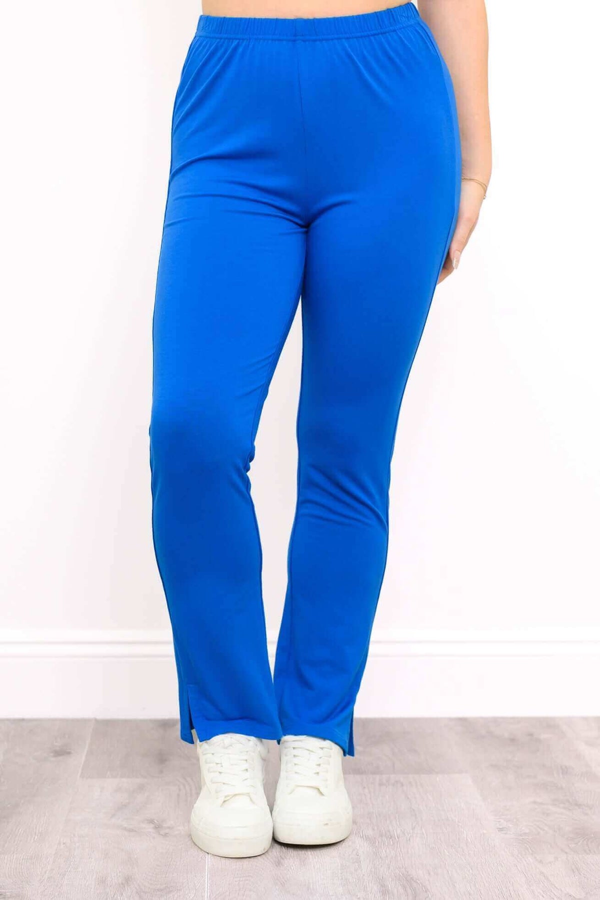Full front view of slim blue bamboo pants styled with casual sneakers
