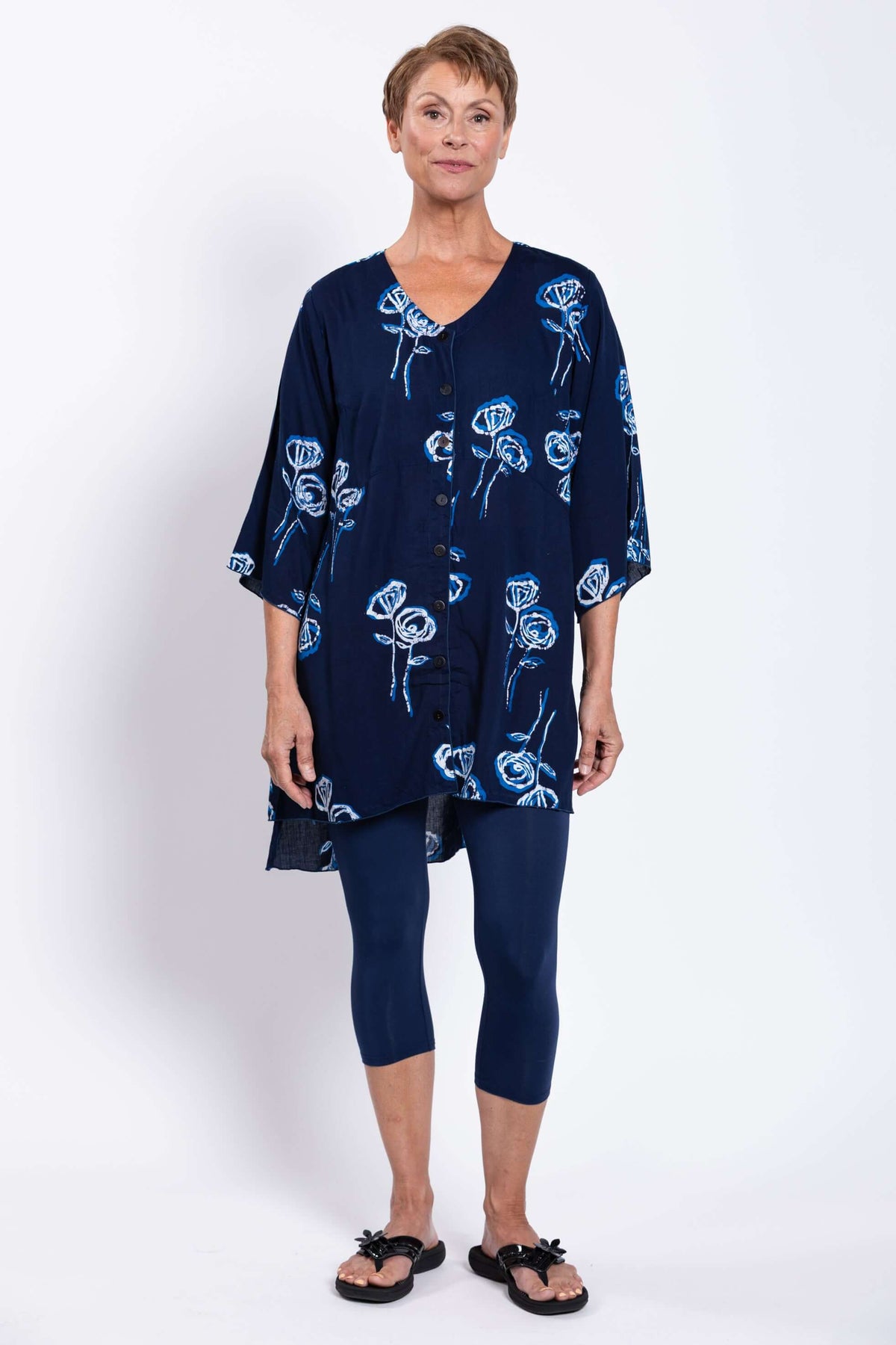Front facing woman in navy floral Darla blouse and navy leggings