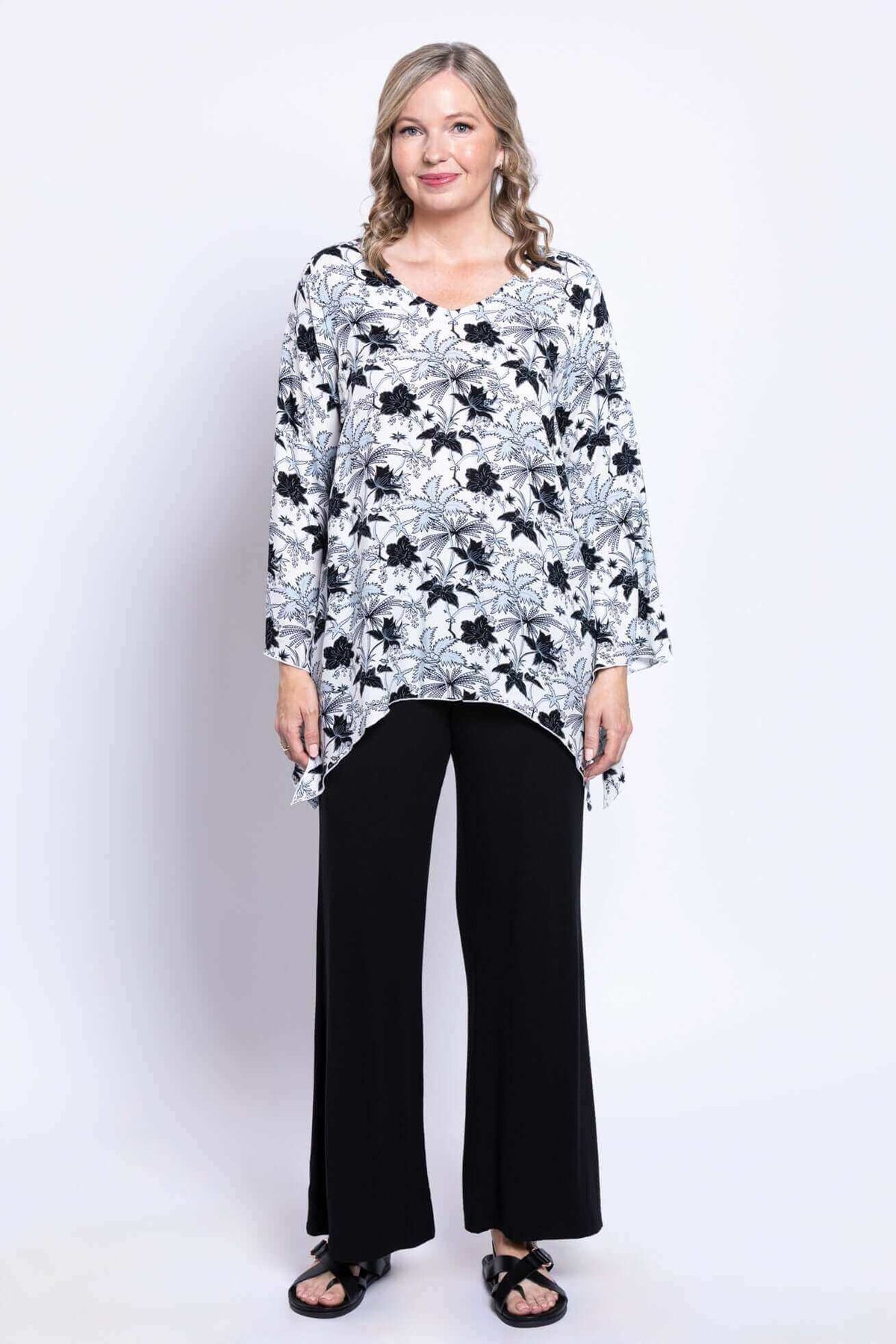 Full front view of woman modeling Dorothy black and white floral boho top and black pants