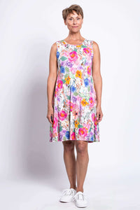 Full front view of woman modeling colorful floral knee-length dress with white sneakers
