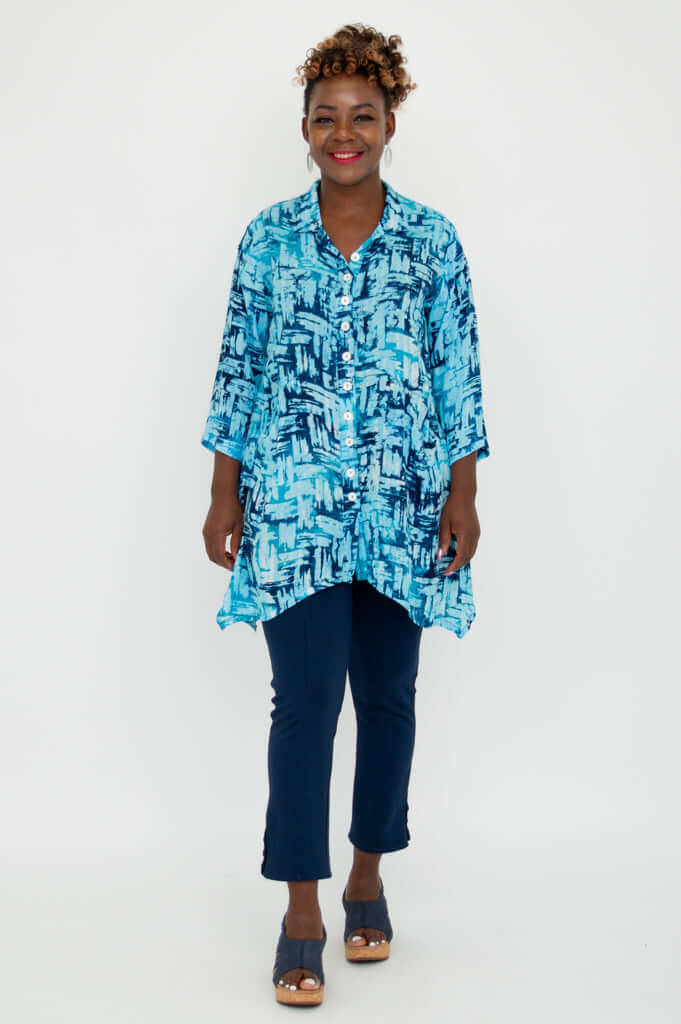 Woman standing front-facing, wearing Laney Blouse in blue print and navy pants
