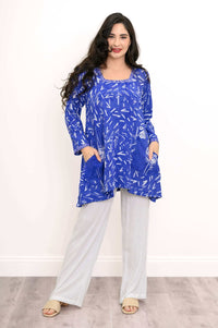 Full front view of woman modeling blue Maria tunic with shark-bite hem and white pants
