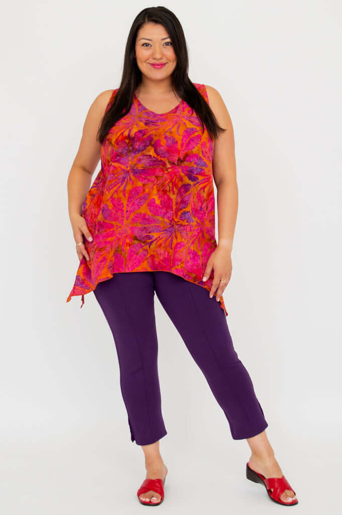 Full front view of a model in an orange and pink sleeveless tank top with purple pants