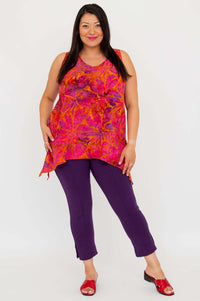 Full front view of a model in an orange and pink sleeveless tank top with purple pants