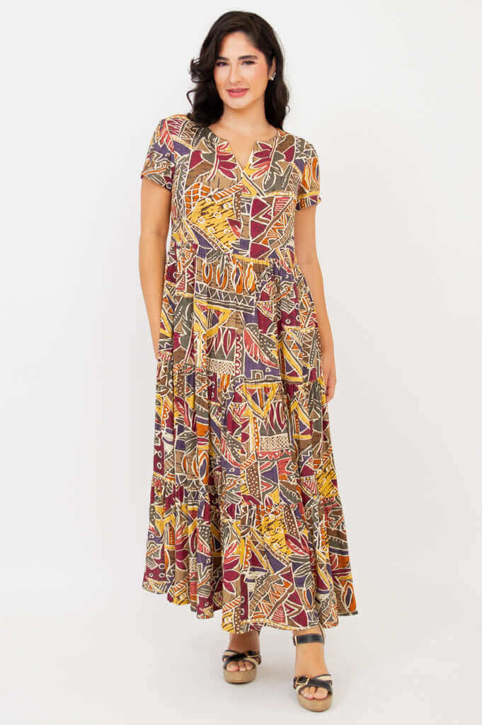 Woman modeling a geometric print maxi dress with empire waist, standing front view