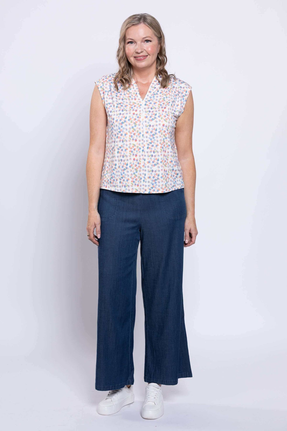 Full front view of model in Paula Top with multicolor print and wide-leg navy pants
