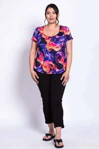 Full front view of model in colorful Ritzy Short Sleeve Top and black pants