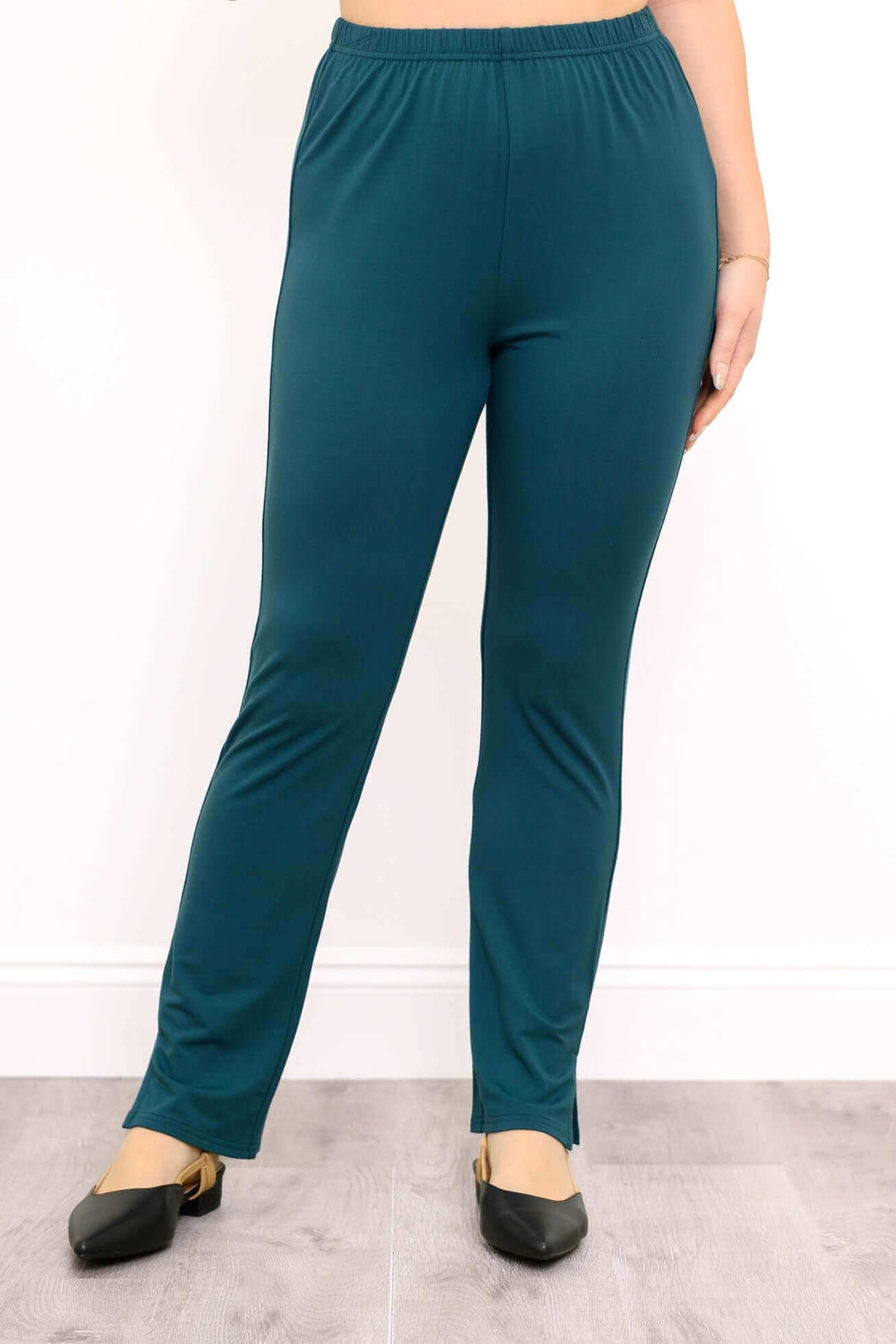 Full front view of teal slim-fit bamboo pants with black flats showing ankle slit