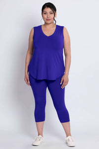 Model showing front view of blue capri leggings and matching sleeveless top
