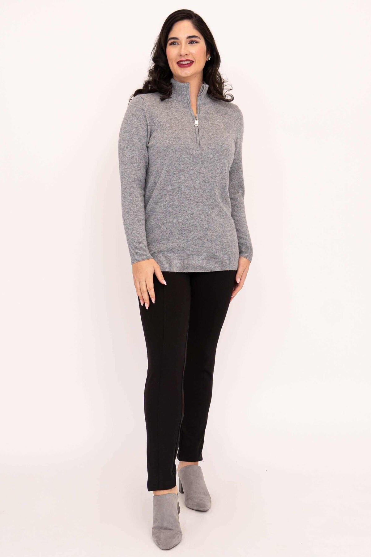 Woman in grey half-zip cashmere wool sweater and black pants, facing forward