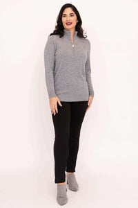Woman in grey half-zip cashmere wool sweater and black pants, facing forward