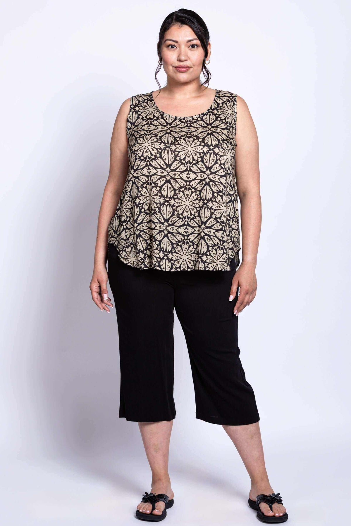Full front view of model in black floral printed sleeveless tank and black pants