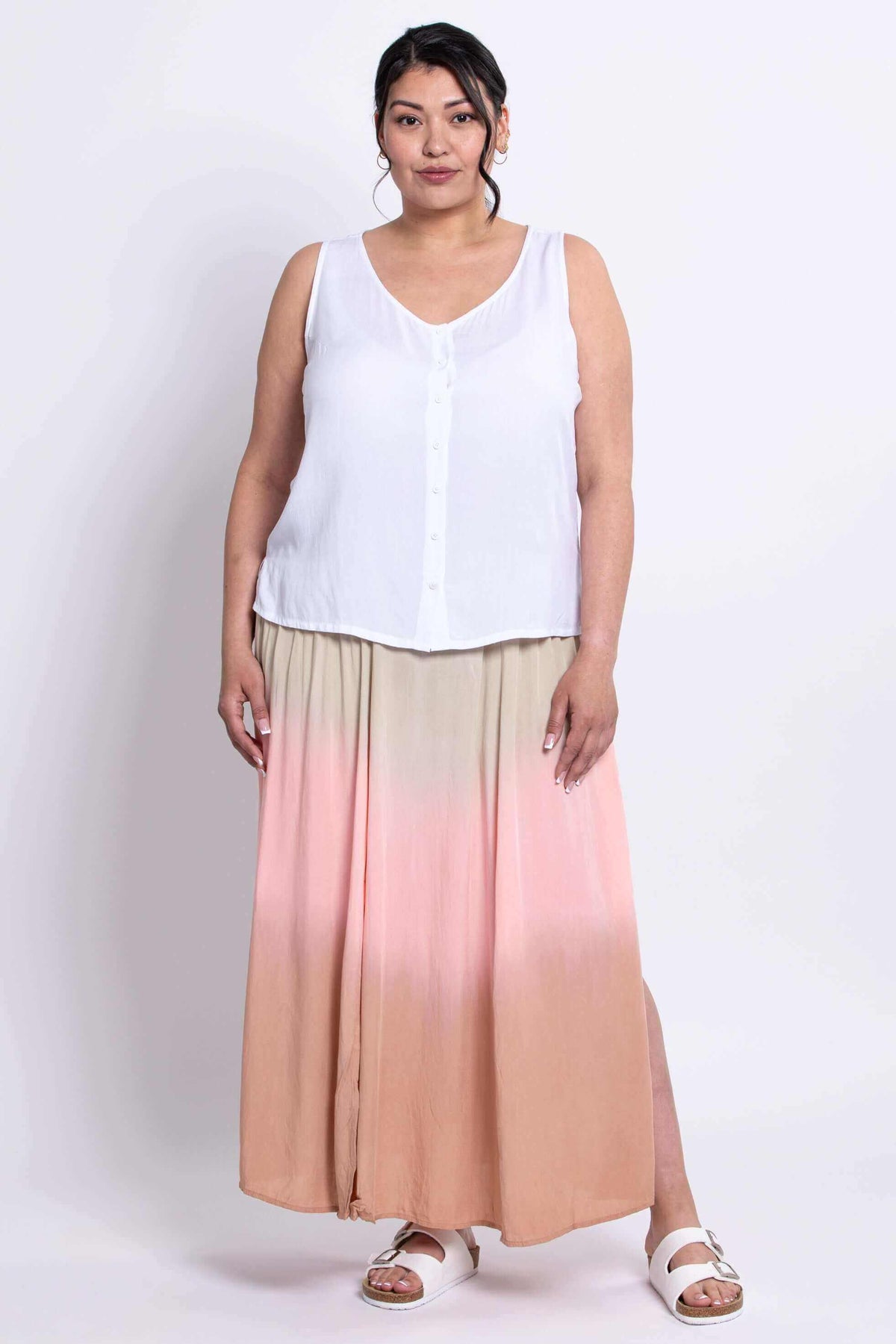 Full front view of model in white sleeveless blouse and dip-dye peach pink skirt