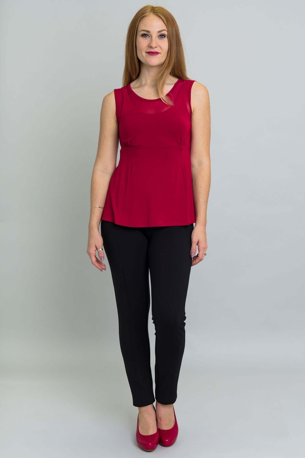 Full body front view of woman in red tank top and black pants