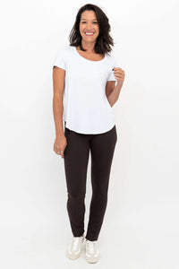 Woman smiling wearing Nadia slim-line brown pants and a white top, full front view