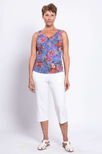 Full body front view of woman in blue floral bamboo tank and white cropped pants