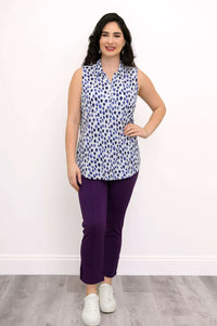 Full front view of woman in blue dot print sleeveless tank and purple pants