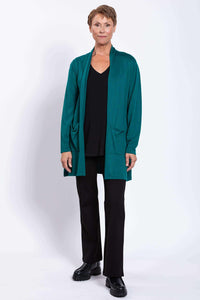 Full front view of woman in teal cardigan, black pants, and black shoes