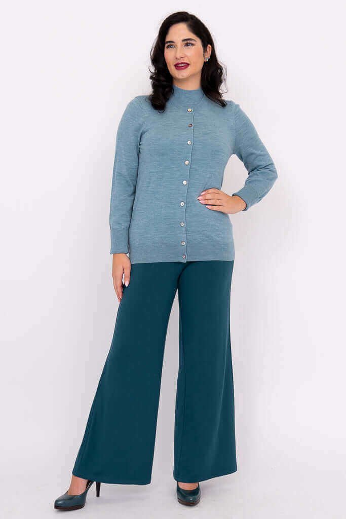 Full front view of woman wearing blue crew neck cardigan and teal pants