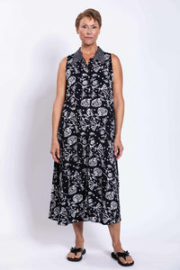 Full frontal view of woman in black A-line dress with white floral graphics