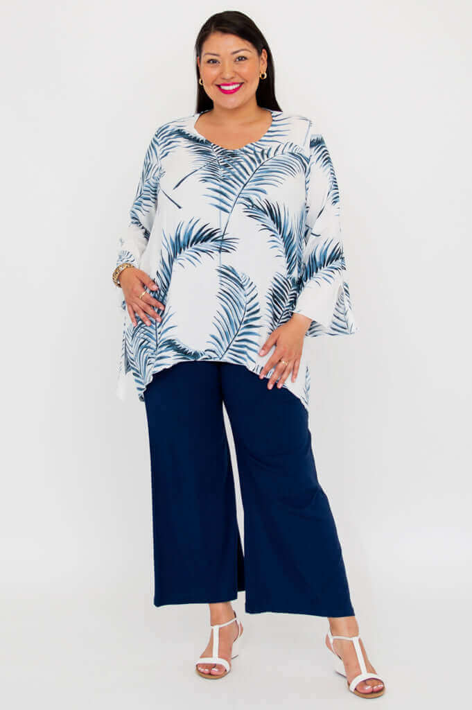 Woman in white and blue palm print top with navy pants, front full length