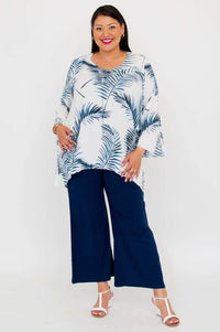 Woman in white and blue palm print top with navy pants, front full length