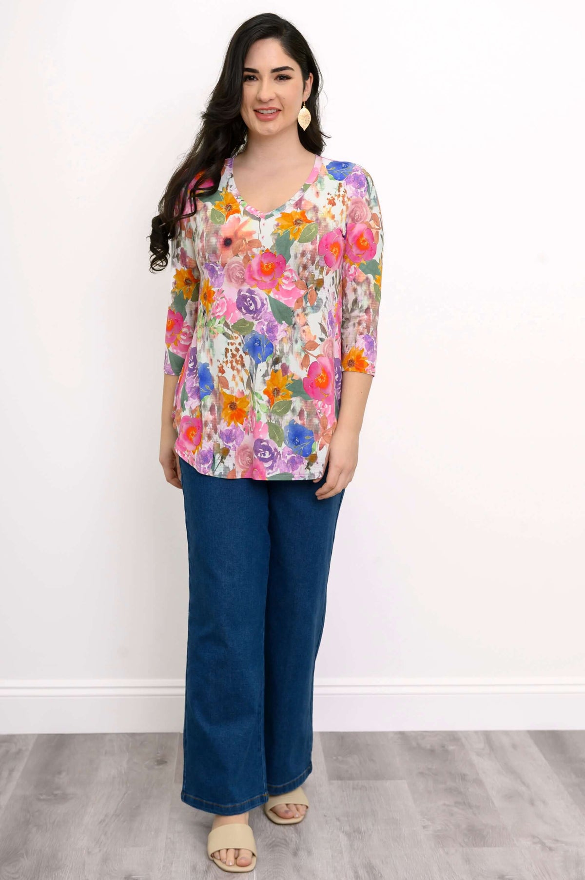 Full body view of a woman in a floral V-neck bamboo top and wide-leg jeans