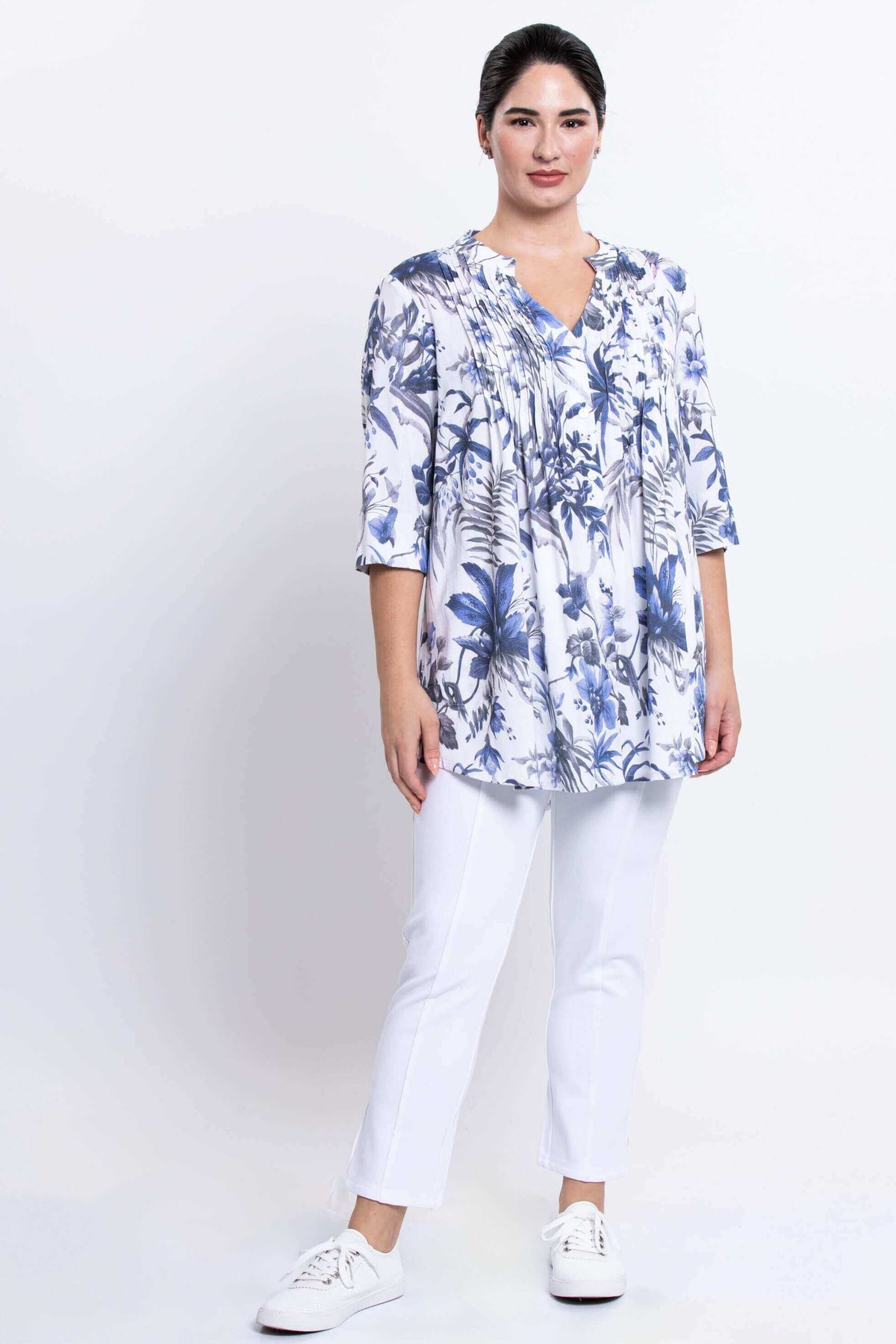 Woman standing in Margate floral blouse and white pants, front view