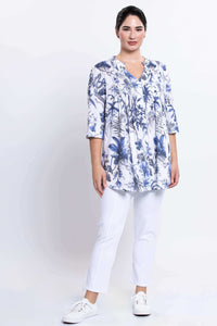 Woman standing in Margate floral blouse and white pants, front view