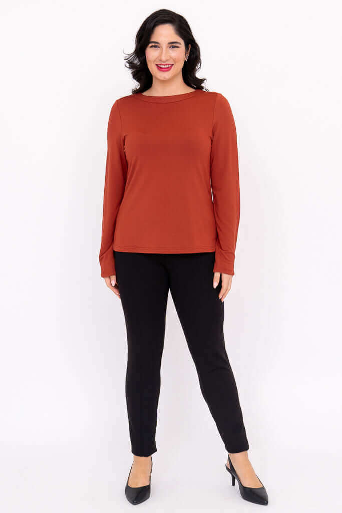 Full length front view of model in Mona boat neck top with black pants and heels