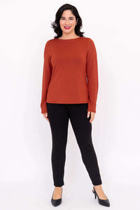 Full length front view of model in Mona boat neck top with black pants and heels