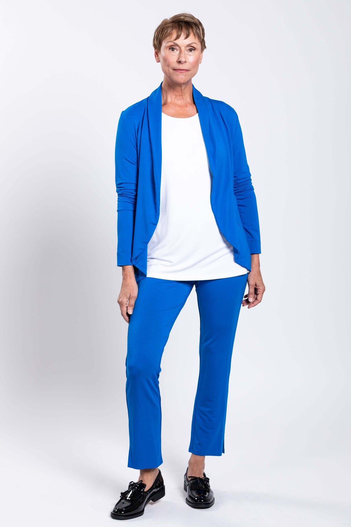 Full length view of woman wearing blue French Terry jacket and pants, white background
