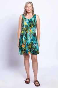 Full view of woman standing in knee-length rainforest print dress, facing forward