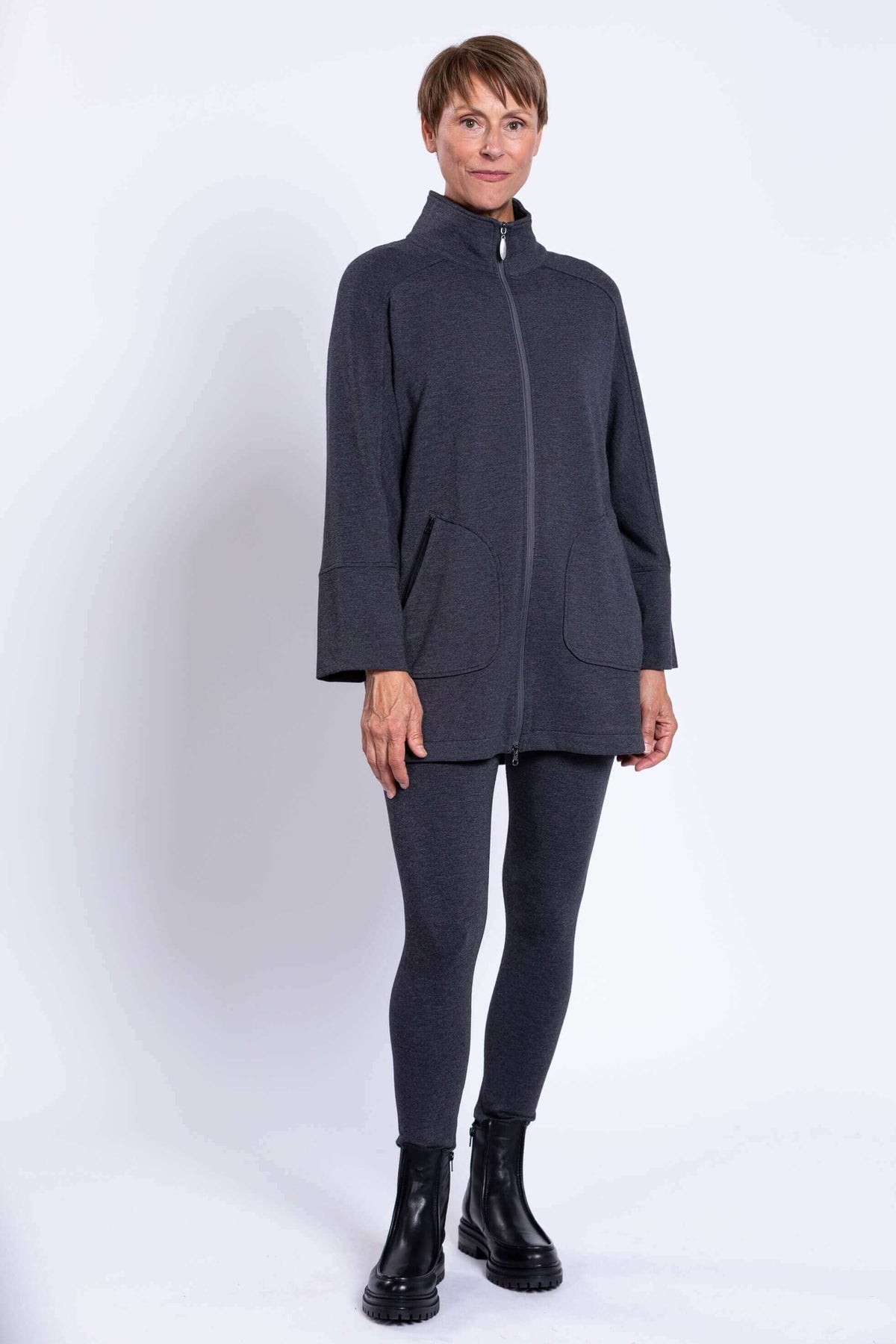 Full length front view of a woman with a zipped high collar jacket and matching leggings