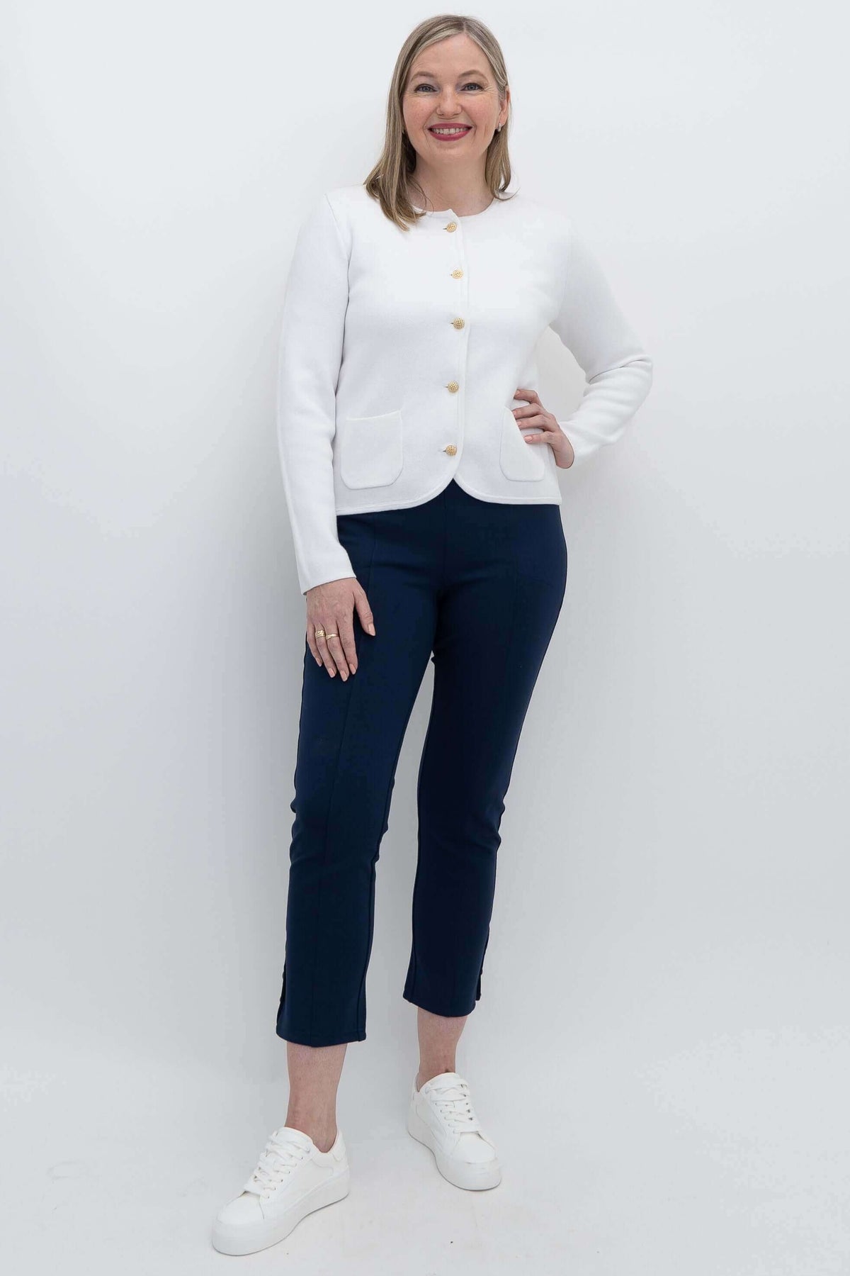 Full length view of woman in ivory gold button cardigan and navy pants