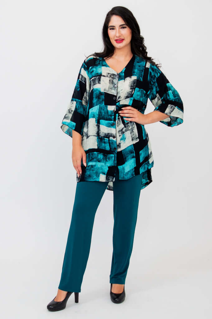 Full body view of woman in Darla blouse and teal pants, standing front-facing