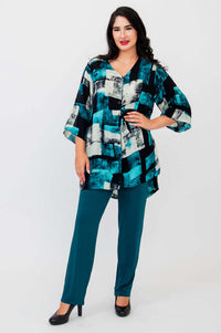 Full body view of woman in Darla blouse and teal pants, standing front-facing