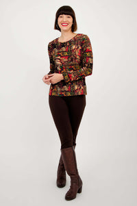 Model in Mariah printed tee, brown pants, and boots standing full length