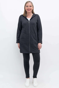 Full body view of woman in dark charcoal hooded jacket and matching leggings