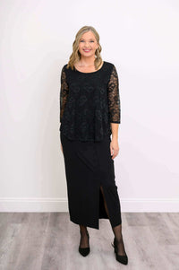Full-length view of woman modeling a black lace top with long black skirt and heels