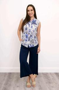 Full body view of woman in blue floral blouse and navy wide-leg pants