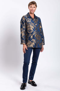 Full view of woman in blue jacquard coat and navy pants