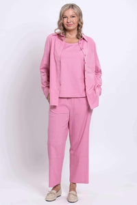 Full body view of a woman in pink linen blend shirt and pants set with tan loafers