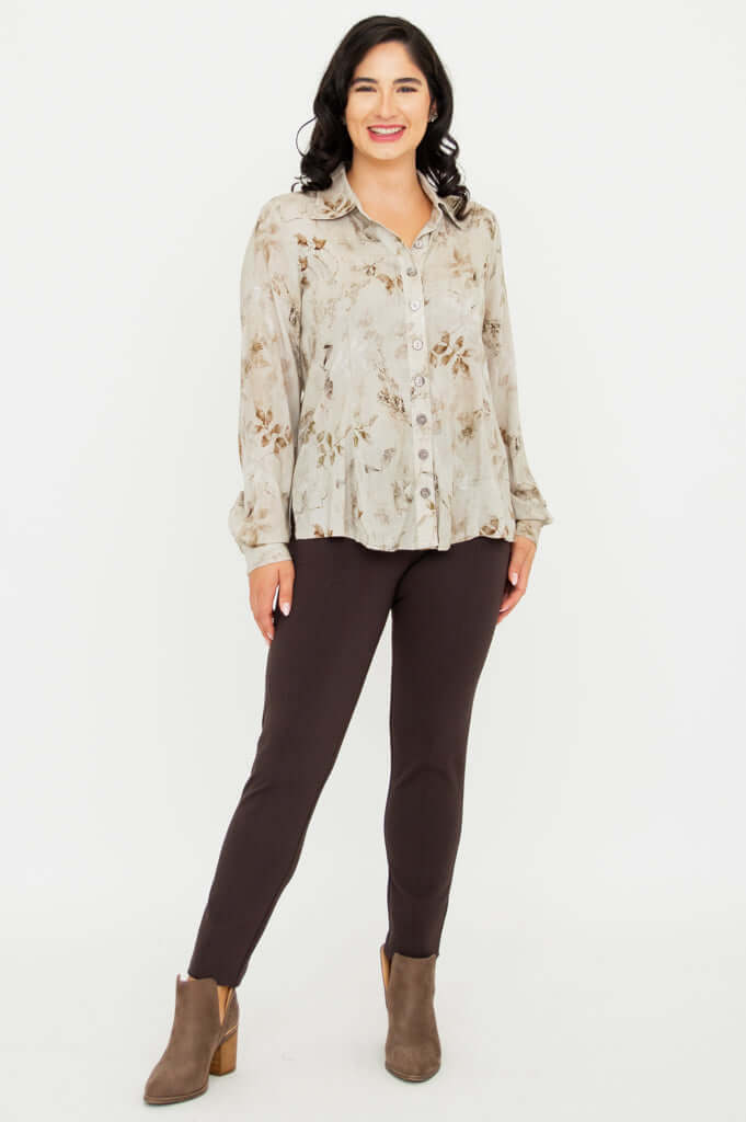 Full body view of woman wearing beige floral blouse and brown pants