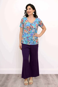 Woman modeling a blue floral short sleeve bamboo top and purple pants, full body