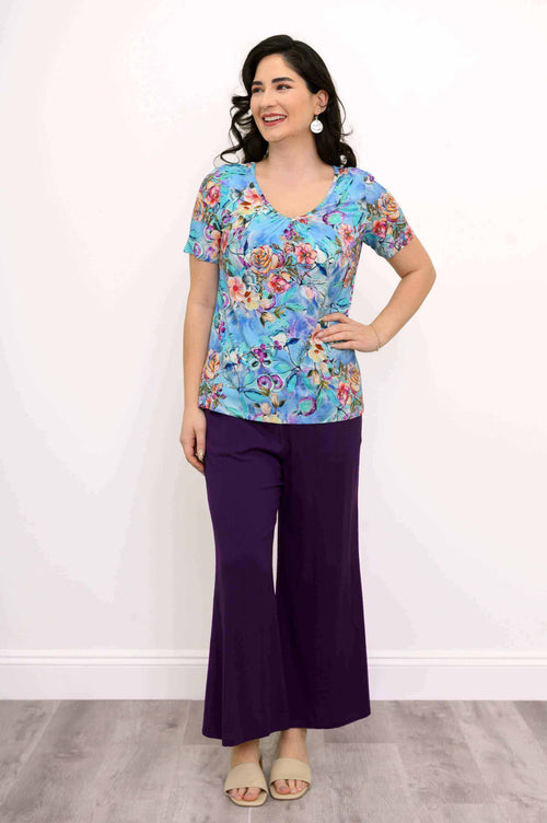 Woman modeling a blue floral short sleeve bamboo top and purple pants, full body