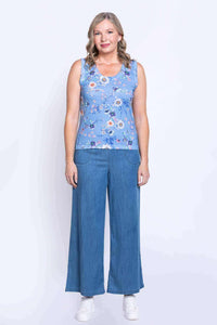 Full body view of woman modeling a blue floral tank top and wide-leg jeans