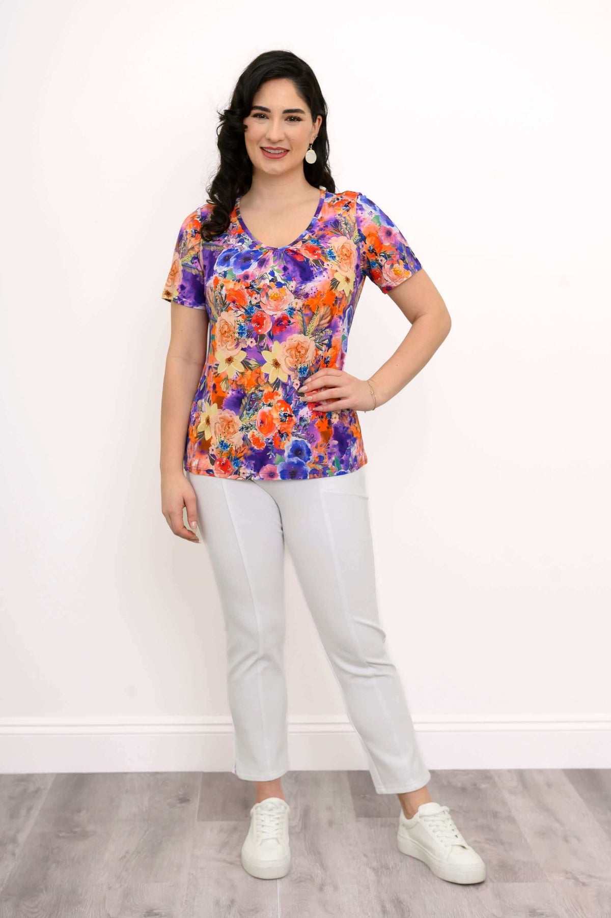 Woman in a vibrant floral bamboo top and white pants, full outfit